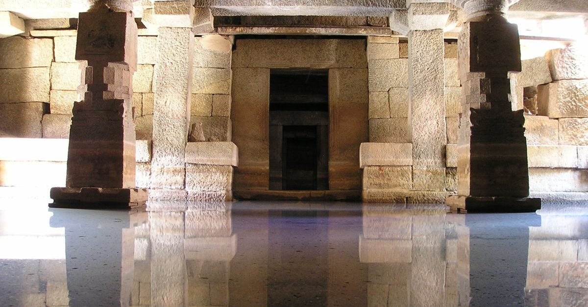 Stunning view of an ancient stone temple interior with water reflections.