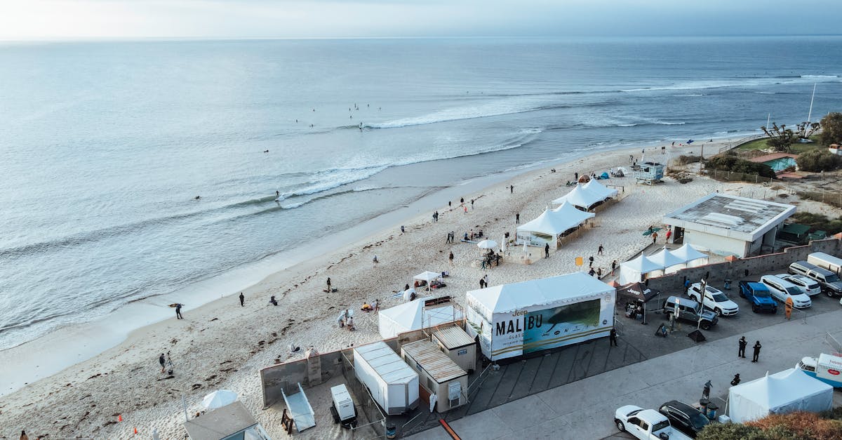 Aerial shot of a beach in Malibu featuring tents and people enjoying the coastal scenery.