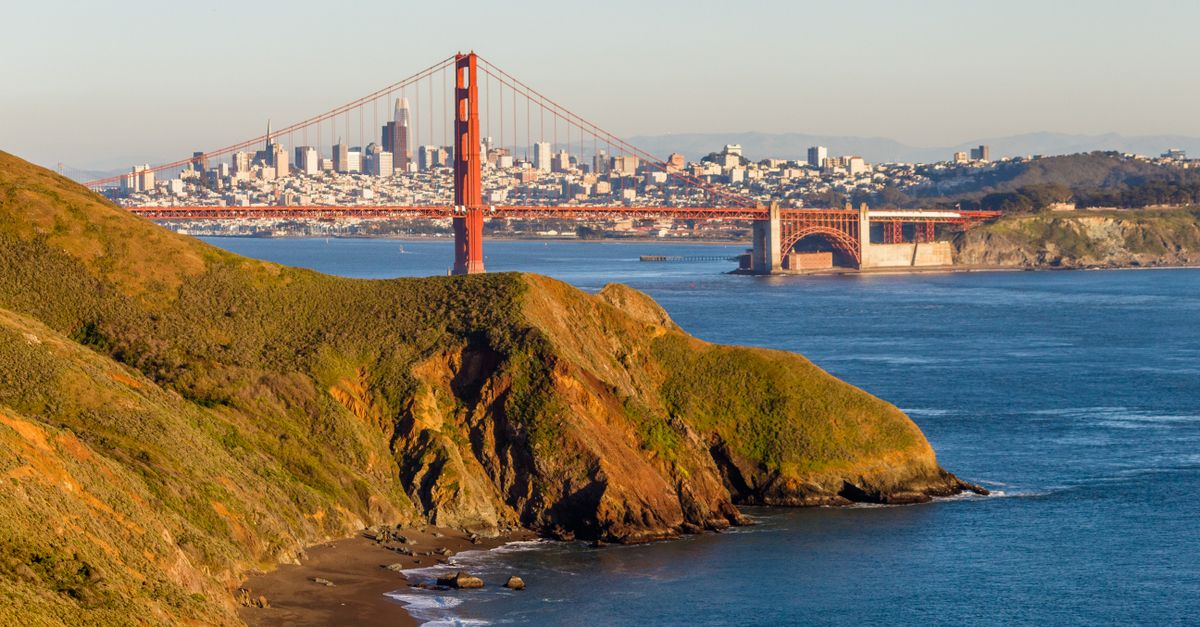 Stunning view of Golden Gate Bridge with San Francisco skyline in the background under clear skies.