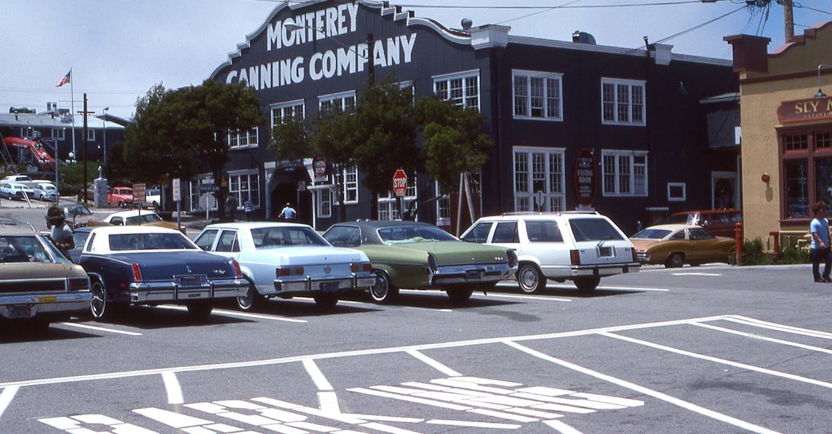 Classic cars parked at the historic Monterey Canning Company lot, capturing a vintage atmosphere.