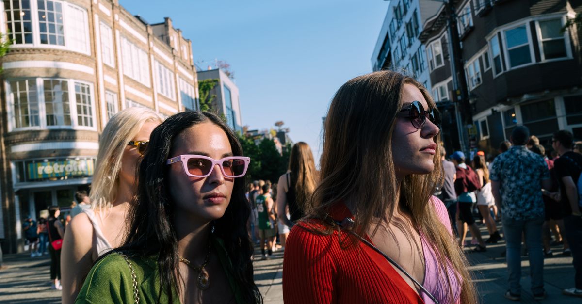 Trendy women wearing sunglasses walking on a sunny day in Seattle's urban streets.