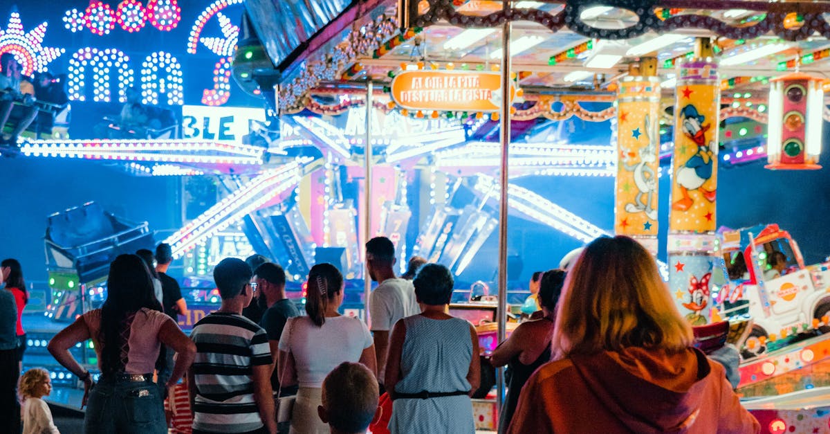 People enjoying a lively night at a colorful funfair with bright lights and amusement rides.