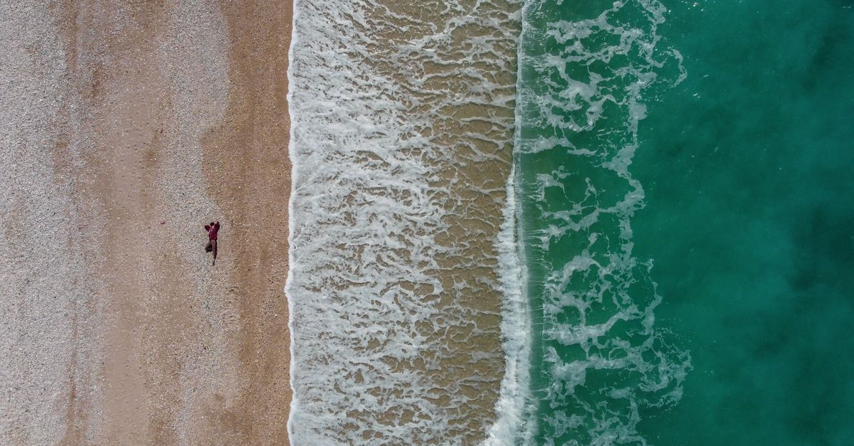 Explore the stunning aerial view of Borsh Beach, Albania with waves crashing on the shore.