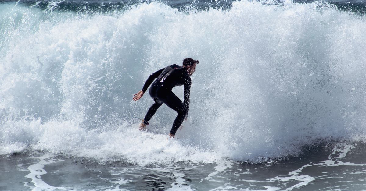 Dynamic shot of a surfer catching a wave at Huntington Beach, California.