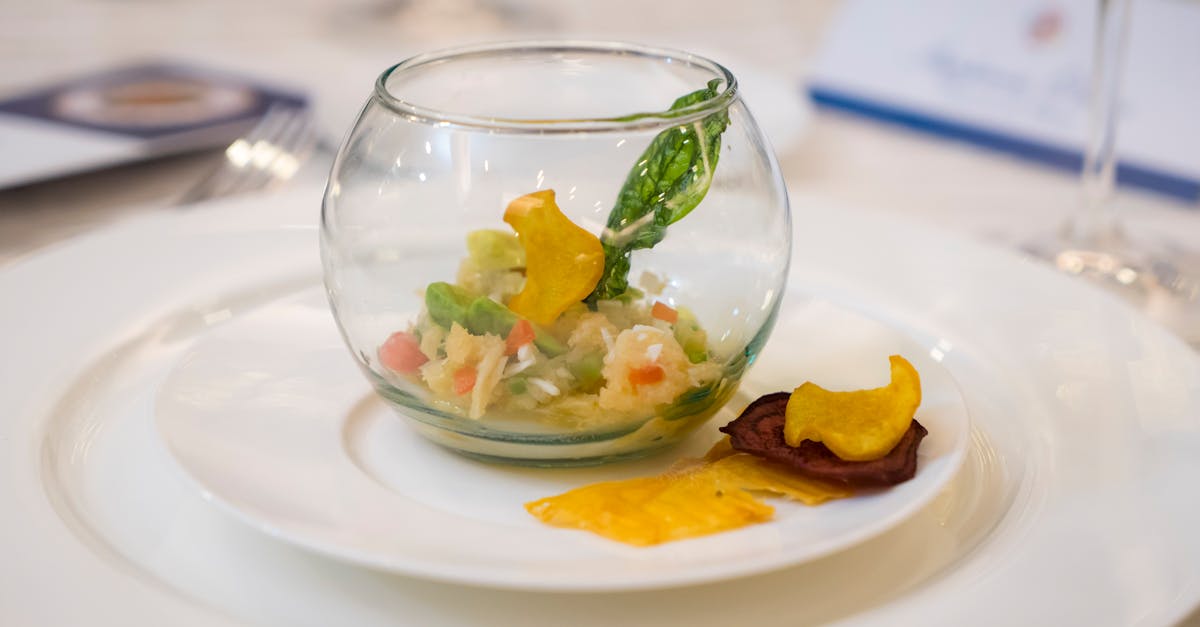 A close-up of a gourmet appetizer served in a glass bowl with a garnished plate, perfect for fine dining settings.