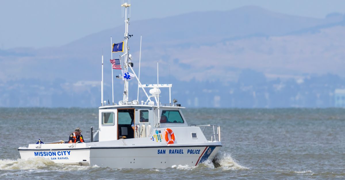 San Rafael Police boat patrolling along a scenic coastline under clear skies.
