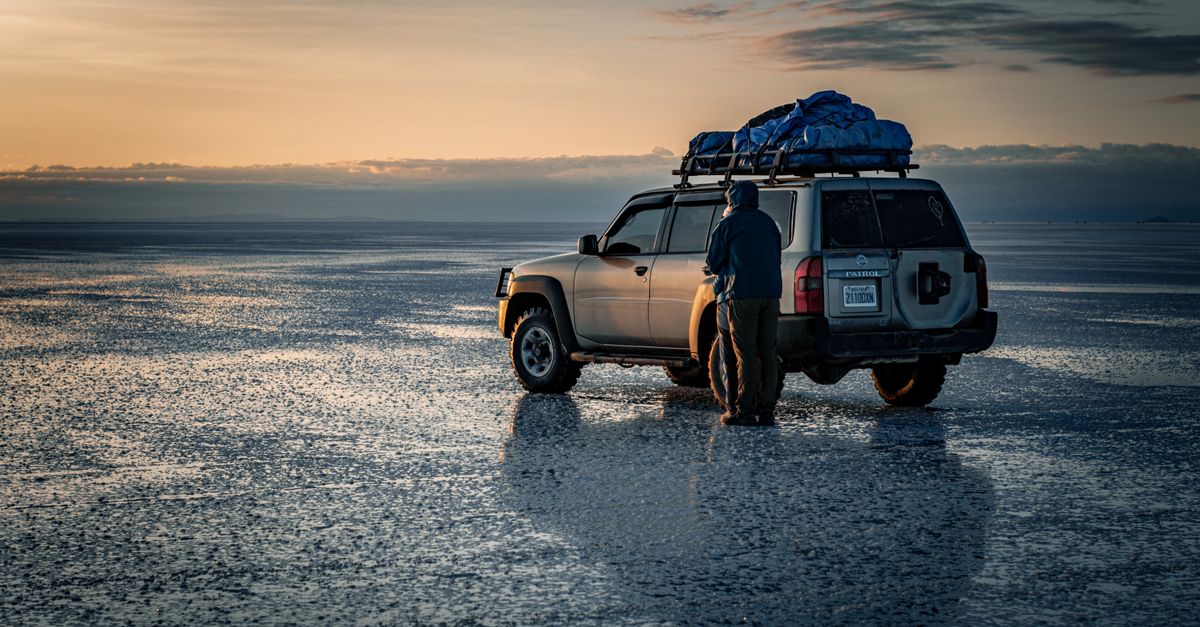 Explore the vast landscape at dawn with an off-road SUV packed for adventure. Perfect for travel enthusiasts.