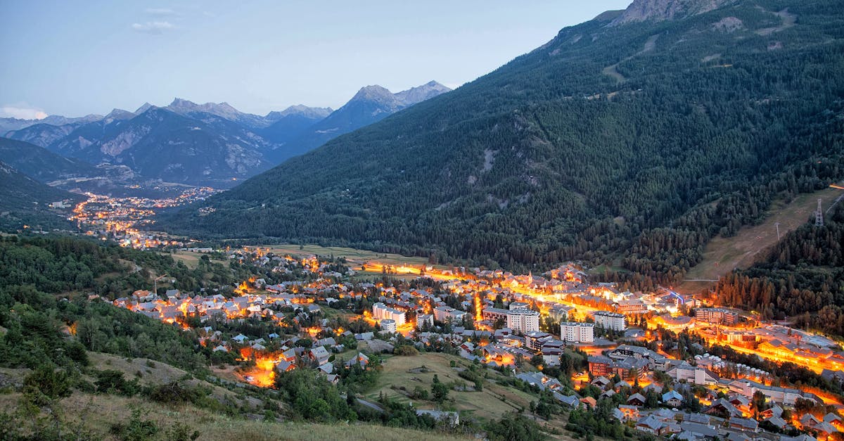 A breathtaking aerial view of La Salle-les-Alpes, France, illuminated at twilight, surrounded by majestic mountains.