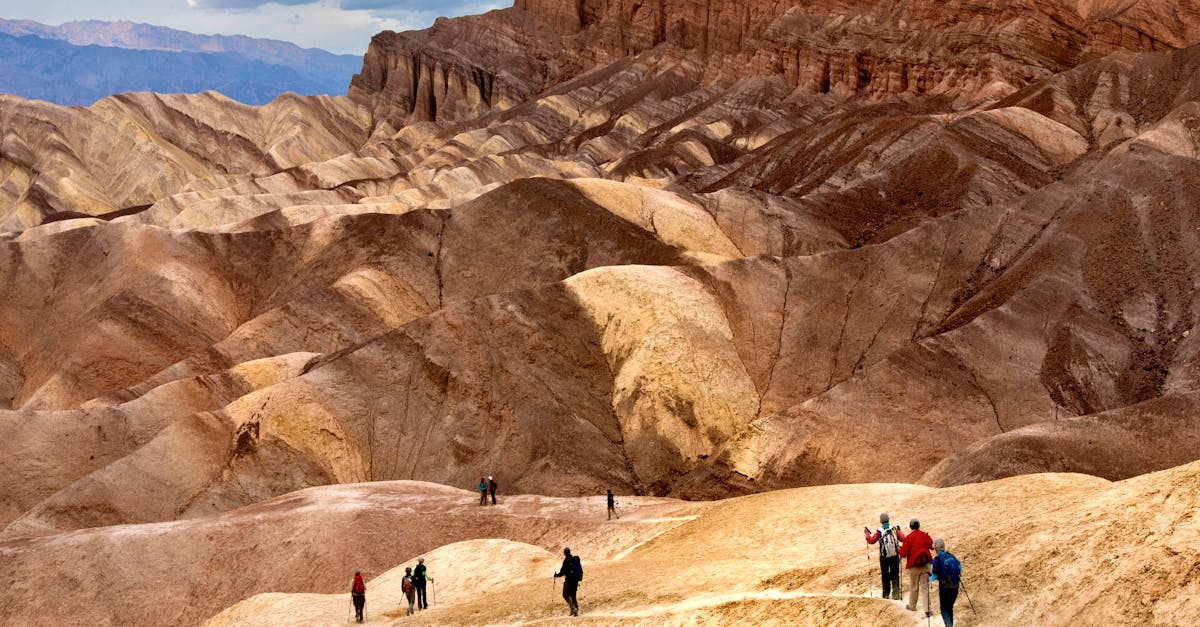 Group hiking through stunning desert dunes under cloudy skies.