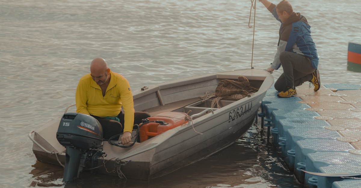 Two fishermen at the pier with a small motorboat, preparing for a day on the water.