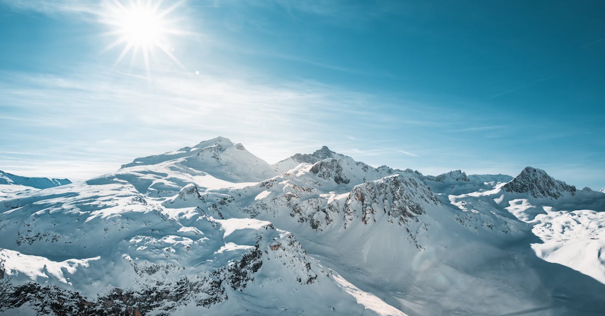 Breathtaking view of snow-covered peaks in Val-d'Isère, France under bright winter sun.