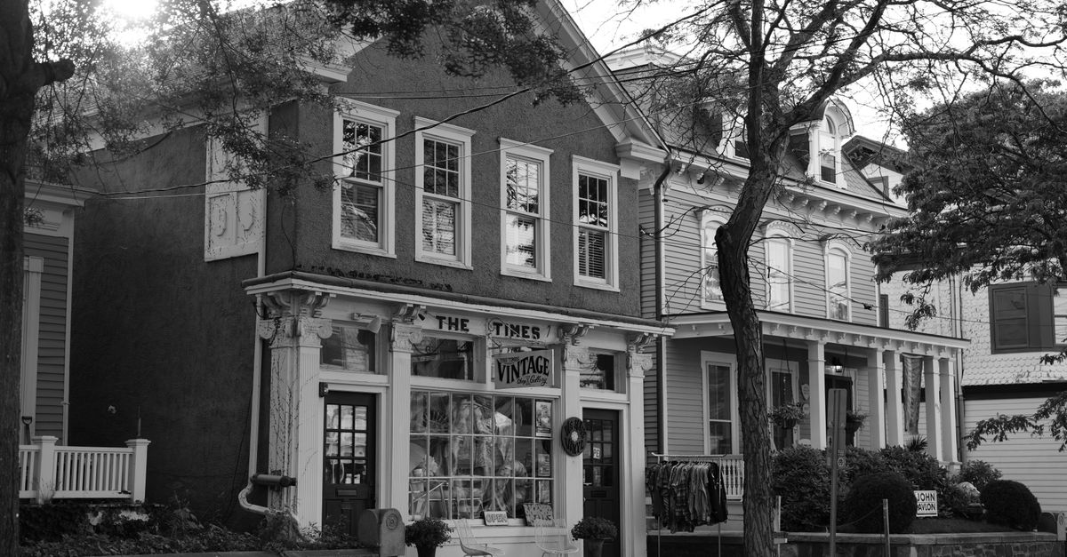Quaint vintage shop facade in a historic town setting, captured in black and white.