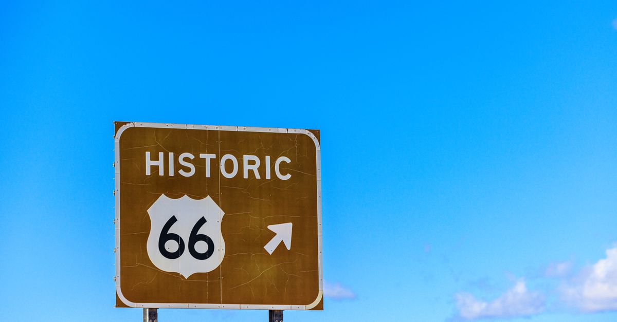 Capture of Historic Route 66 sign with clear blue sky background symbolizing travel and adventure.