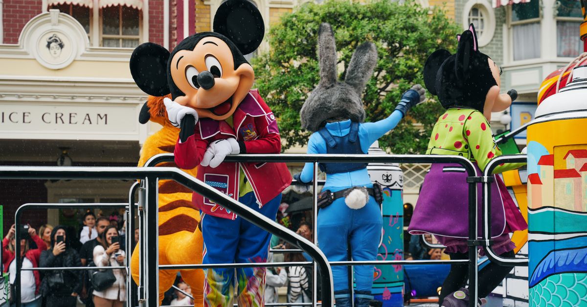 Vibrant Disneyland Paris parade with iconic Disney mascot characters entertaining the crowd.