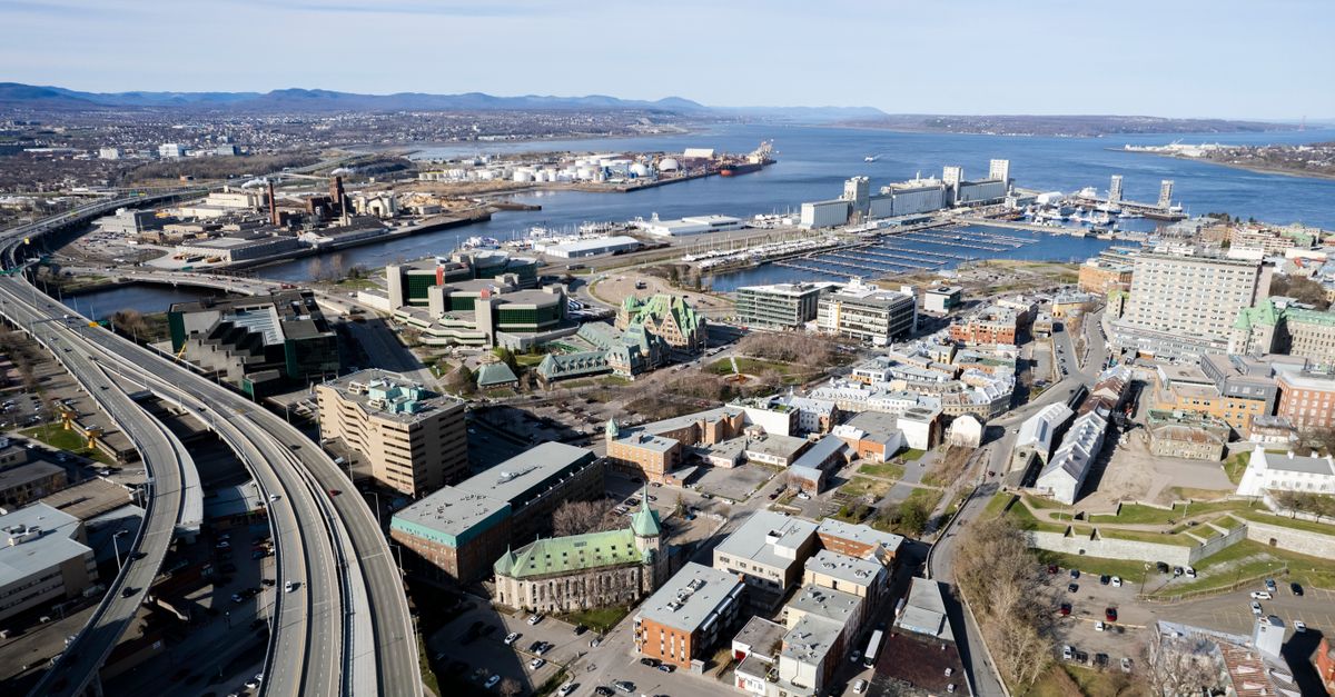 Stunning aerial shot of Québec City skyline with the St. Lawrence River and bustling harbor in view.