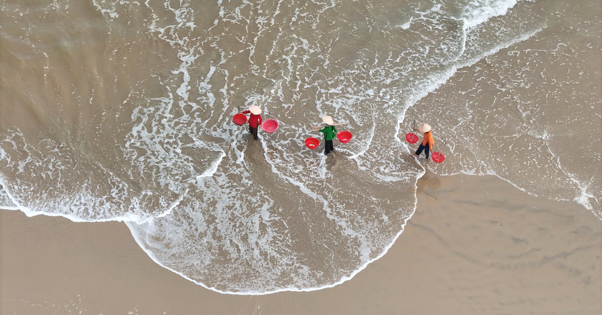 Aerial shot of fishermen with baskets on a beach in Hội An, Vietnam.