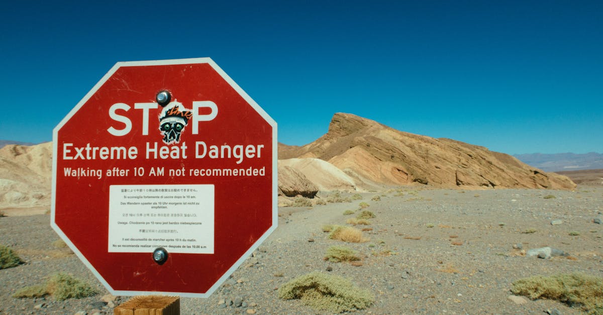 A red warning sign highlights extreme heat danger in a desert area.