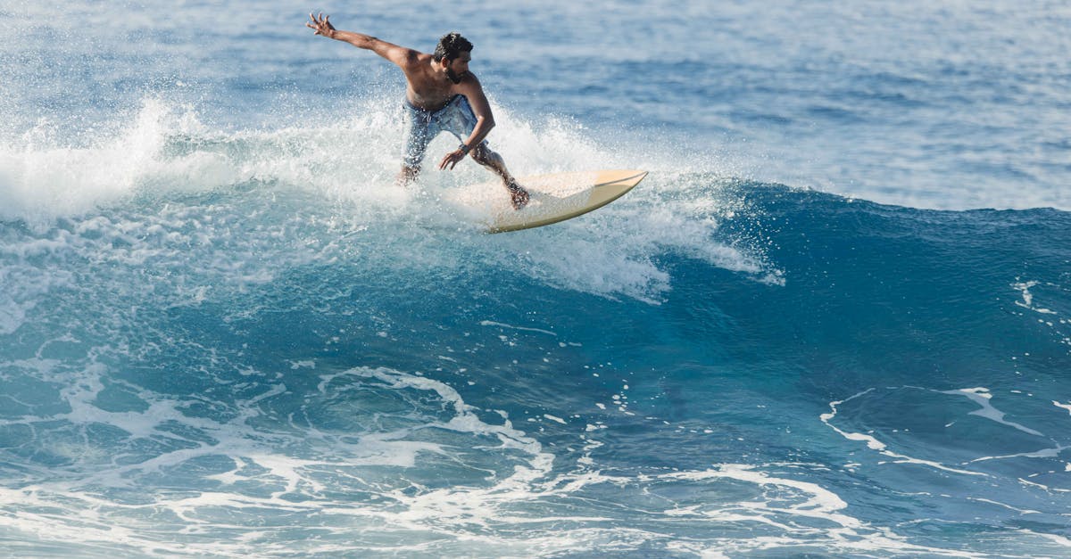 Dynamic shot of a surfer catching a wave in the crystal blue waters of the Maldives.