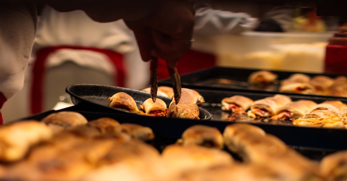 Close-up of pizza rolls being served at a Düsseldorf food market, showcasing Italian cuisine.