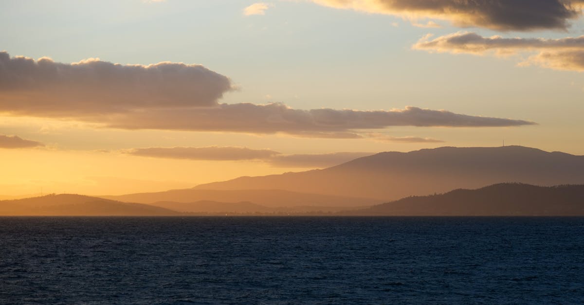 Breathtaking view of a sunset over the ocean with distant hills in Tasmania, Australia.