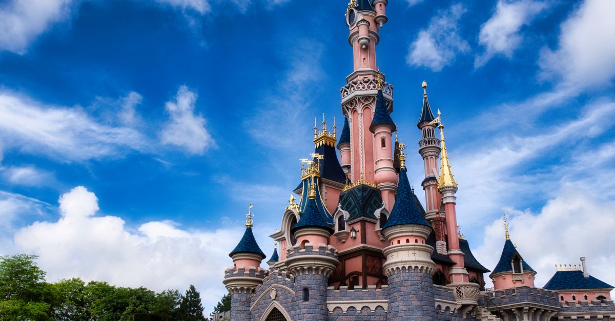 Magical view of the iconic Disneyland Paris castle with a vibrant blue sky.