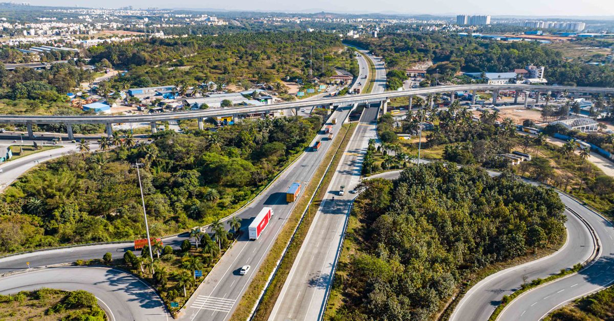 Highway interchange with vehicles in a city from an aerial perspective.
