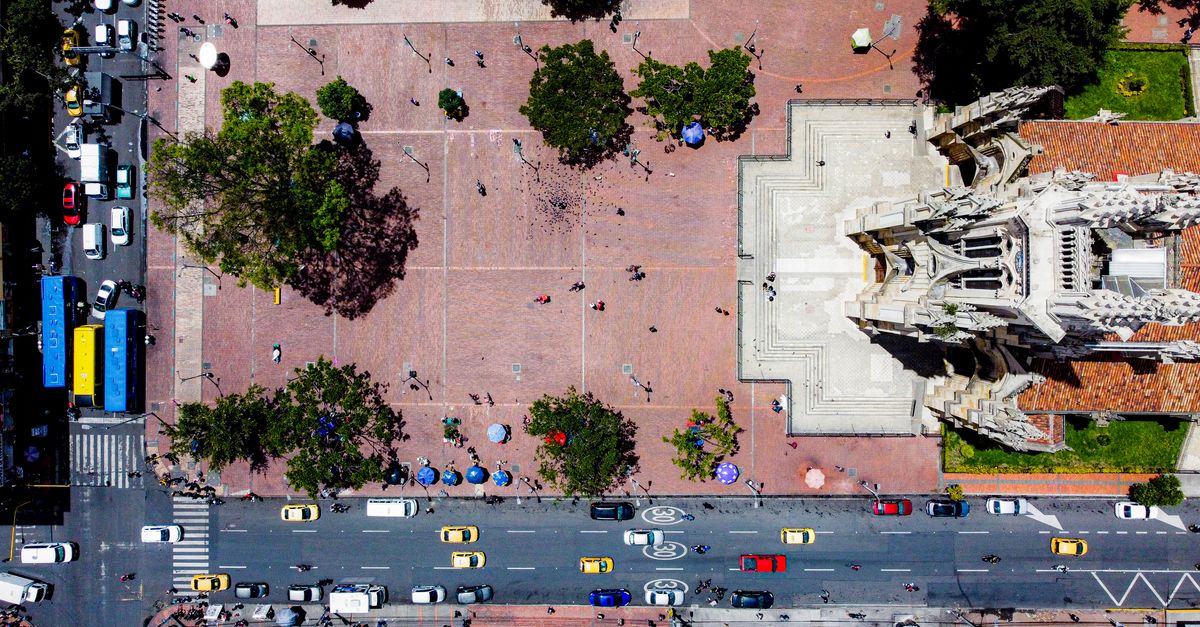 Aerial shot of Bogotá city plaza with bustling street and historic cathedral.