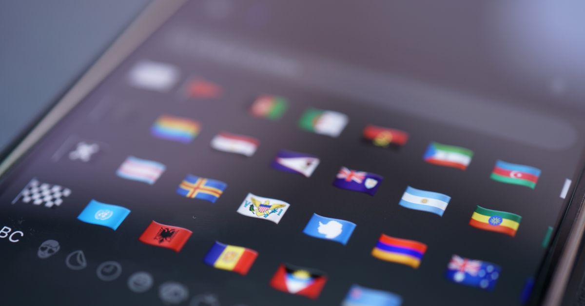 Close-up of a smartphone screen displaying a variety of world flags emojis used for digital communication.