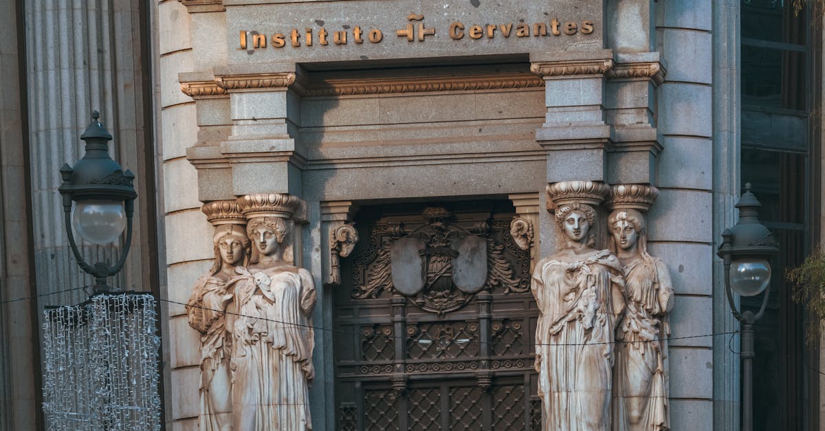Front view of Instituto Cervantes entrance with classical sculptures in Madrid.