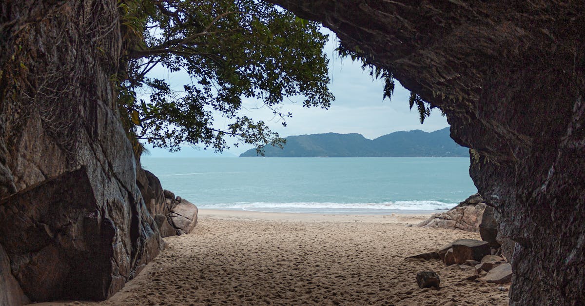 Picturesque view of Ubatuba's beach from within a natural cave, showcasing serene seascape.