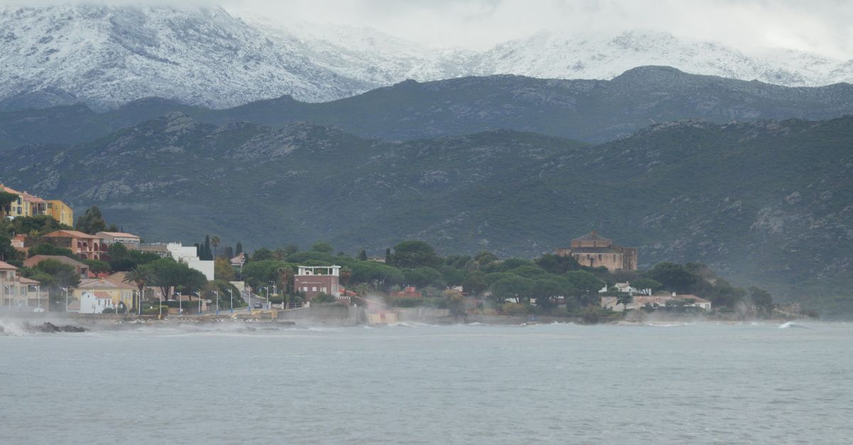 Picturesque coastal view of Saint-Florent, Corsica with misty mountains and charming architecture.