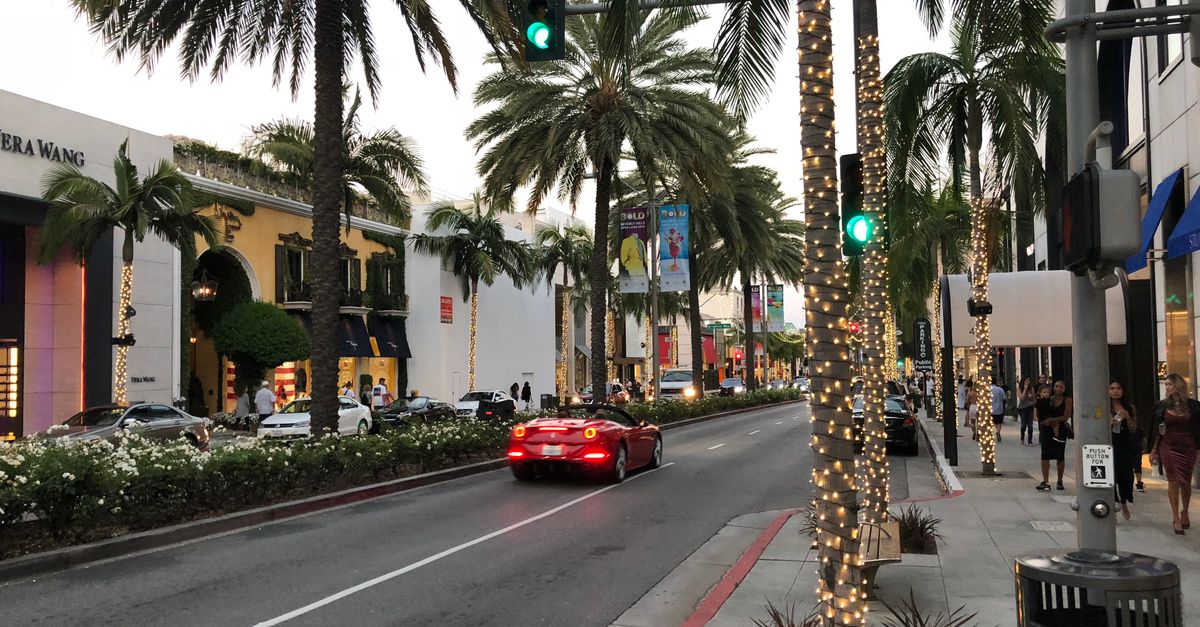 Captivating view of Rodeo Drive with palm trees and luxury shops at dusk in Beverly Hills.