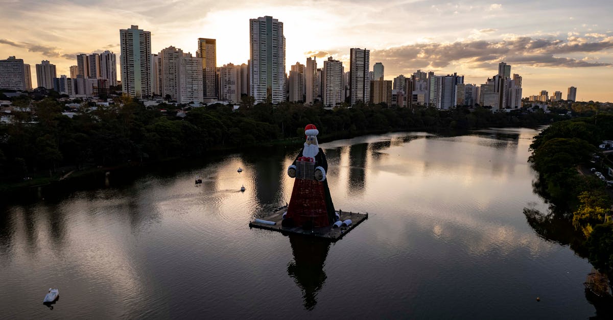 Aerial view of a Santa Claus display at Lago Igapó with Londrina's skyline at sunset.
