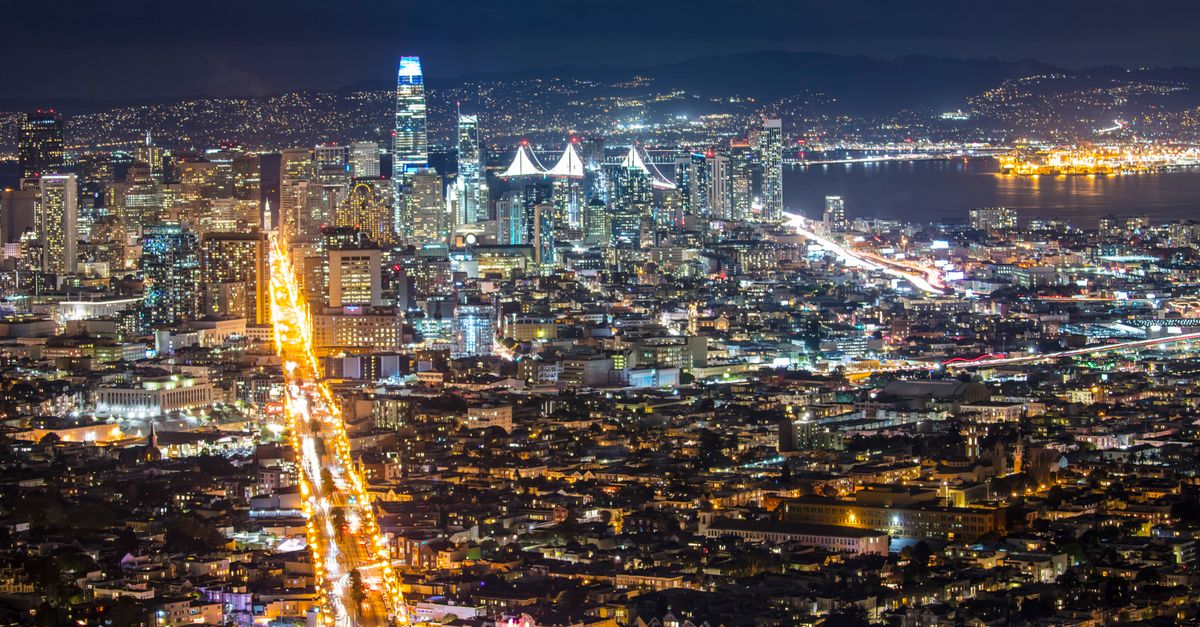 Stunning aerial view of San Francisco skyline illuminated at night with vibrant city lights.