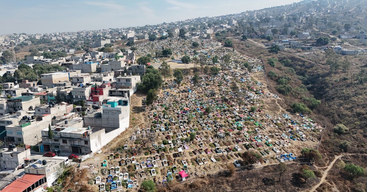 Aerial scene of a cemetery and residential area in Estado de México, showcasing urban and natural contrast.