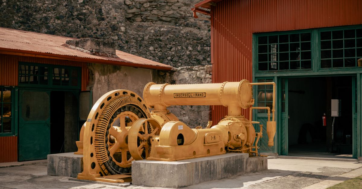 Old mining machinery showcased outdoors at a Mexican museum.