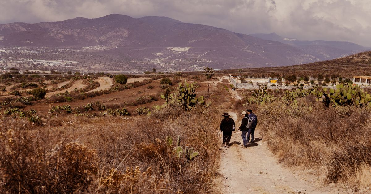 Hikers trekking through the rugged terrain of San Juan Tizahuapan, Hidalgo, Mexico, surrounded by nature.
