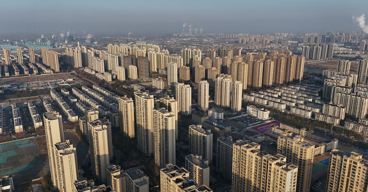 Expansive aerial view of a modern city featuring numerous high-rise buildings under a clear blue sky.