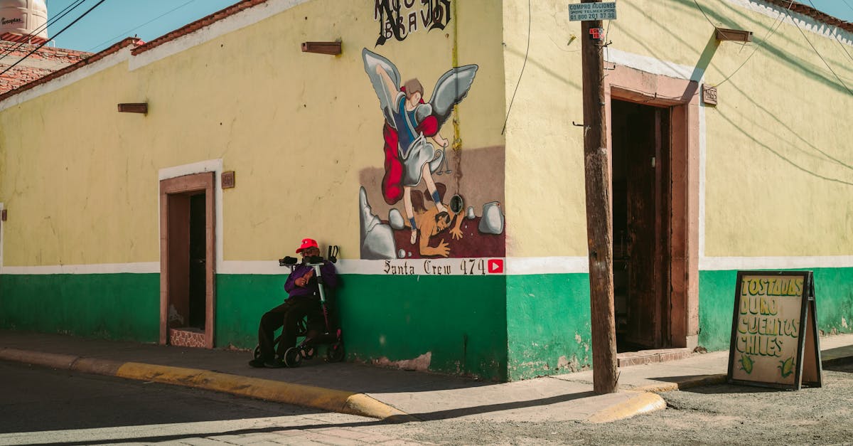 A vibrant street corner featuring a mural, a person resting, and a sign advertising chilies.