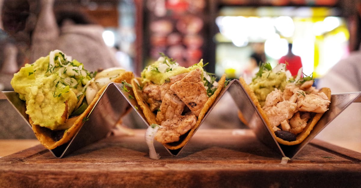 Close-up of delicious chicken tacos with avocado, served in a modern restaurant setting.