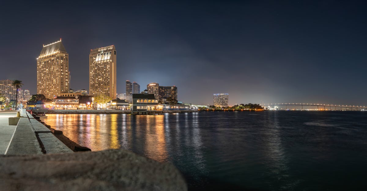 Stunning San Diego skyline featuring Coronado Bridge and glowing city lights reflecting in the bay at night.
