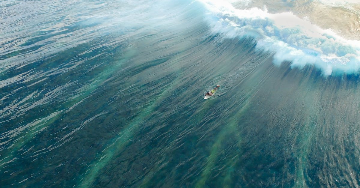 Breathtaking aerial shot of a surfer navigating the waves in Malé, Maldives.