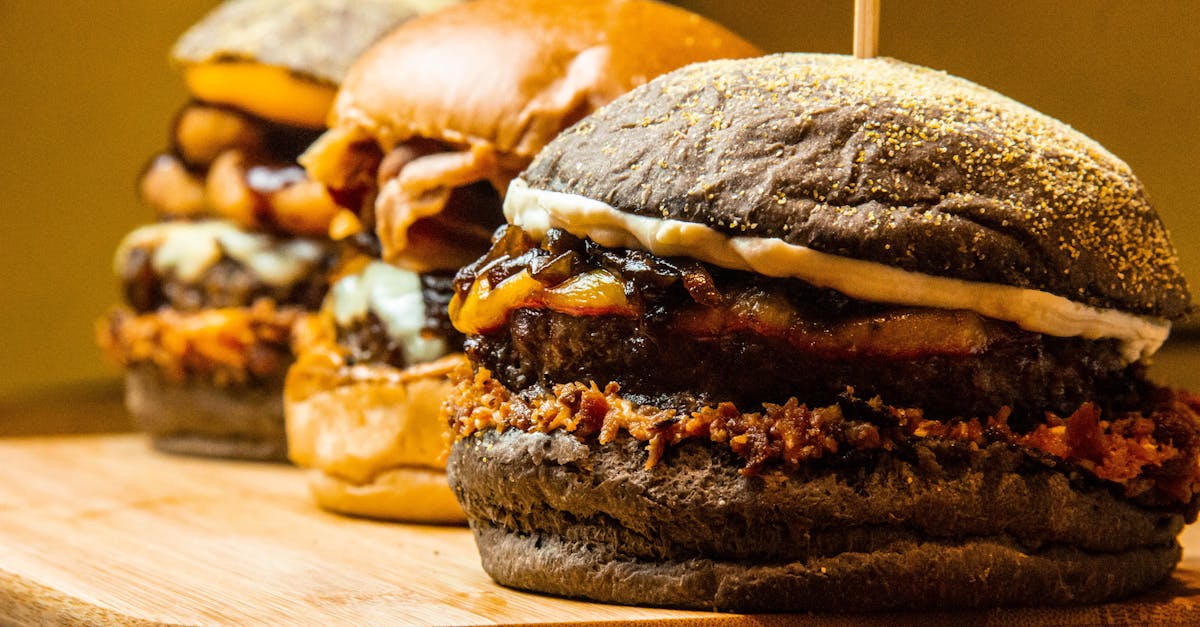 Mouthwatering close-up of gourmet burgers on a wooden board, showcasing delicious textures and toppings.