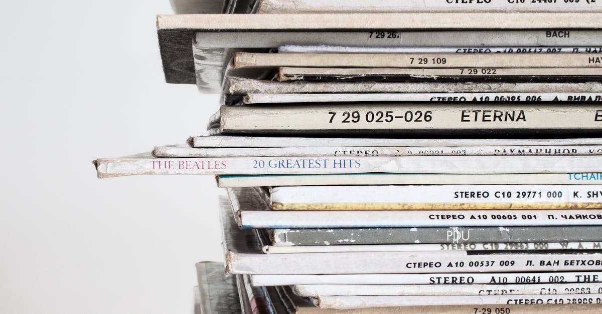Close-up shot of a stacked pile of vintage vinyl record albums showcasing classic music covers.