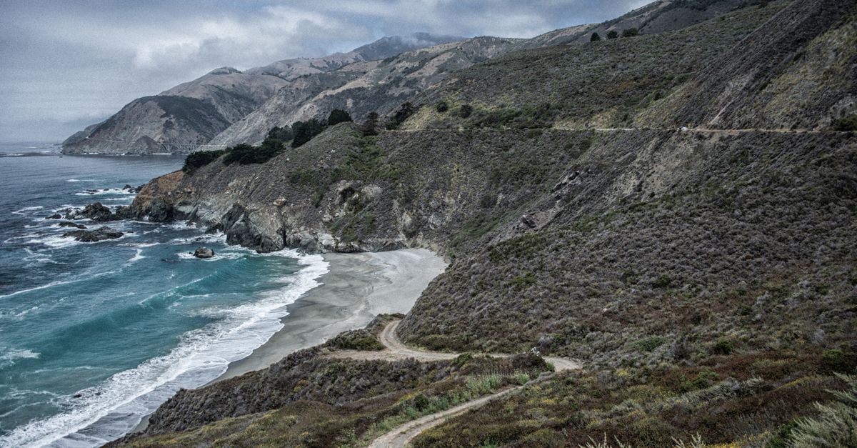 Beautiful coastline with rugged cliffs and a winding path by the ocean.
