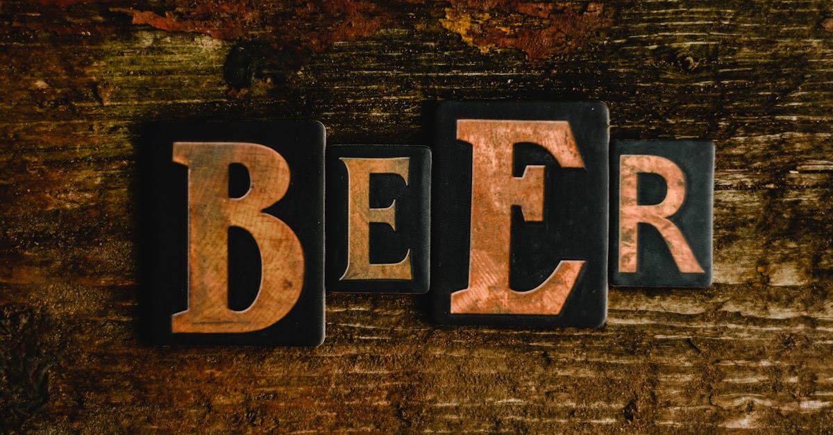 Artistic arrangement of 'BEER' letter tiles on a textured wooden surface, featuring a vintage style.