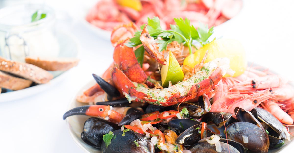 A vibrant seafood platter featuring lobster, mussels, and shrimp, garnished with herbs and lemon.