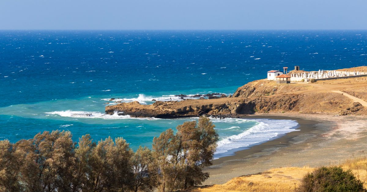 Explore the serene coastal landscape of Pachyammos, Cyprus with a picturesque view of the deep blue sea and rocky shore.
