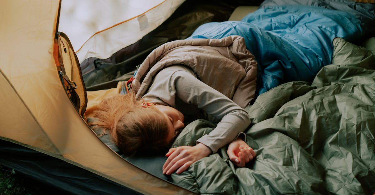A serene scene of a woman sleeping comfortably in a tent during a camping trip, surrounded by nature.