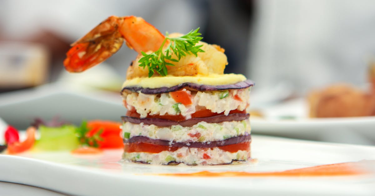 Delicate layers of shrimp, vegetables, and garnish create a gourmet culinary masterpiece.